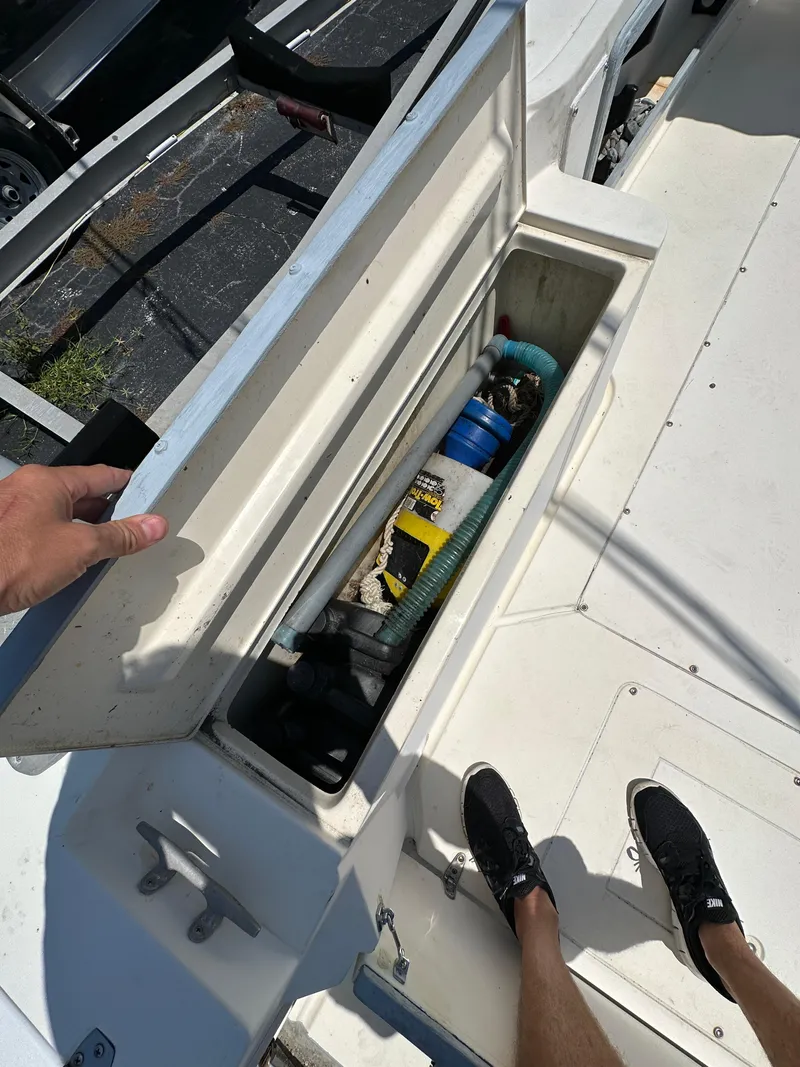 Slide: The Image of Open storage compartment on 1987 Mako 228 boat, containing various tools and equipment. - 21