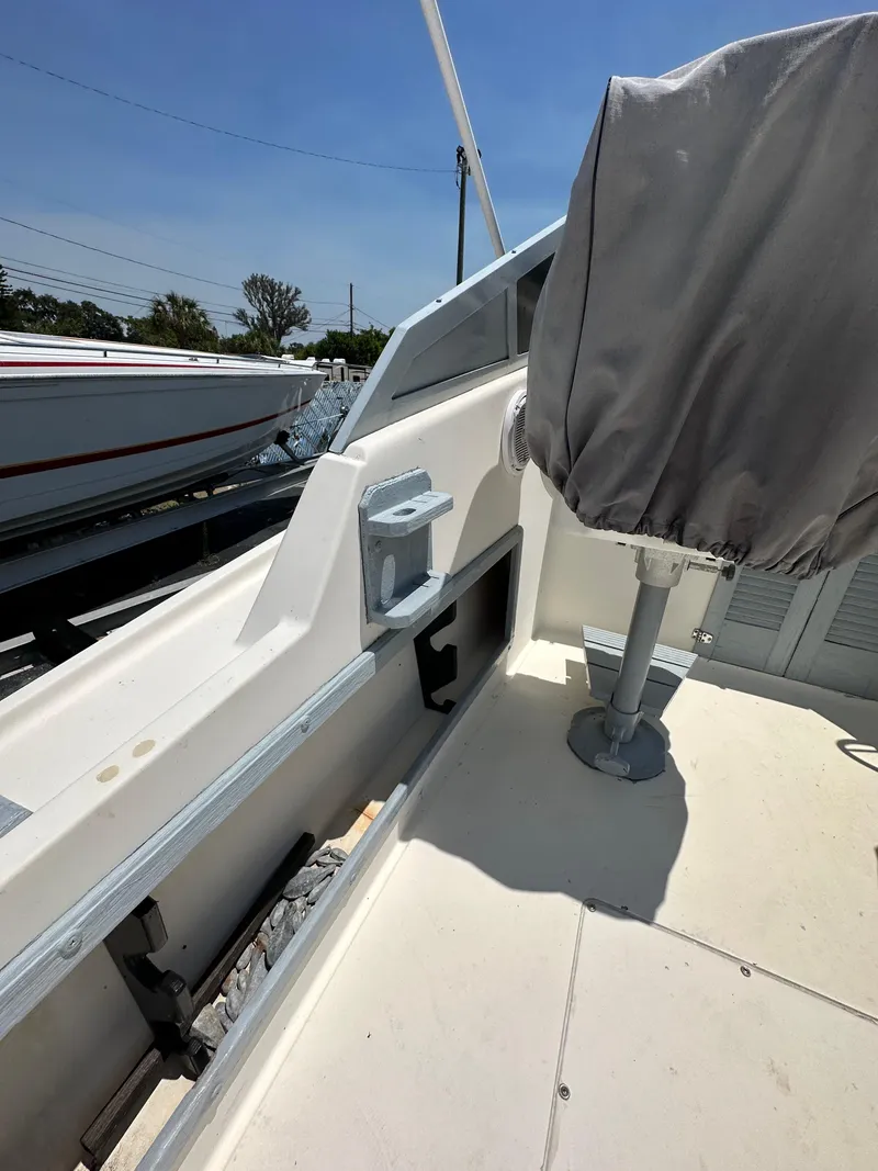 Slide: The Image of 1987 Mako 228 boat interior with covered seat and storage compartments. - 24