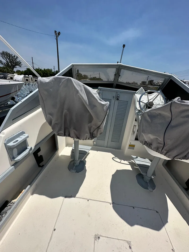 Slide: The Image of 1987 Mako 228 boat cockpit with covered seats under clear blue sky. - 25