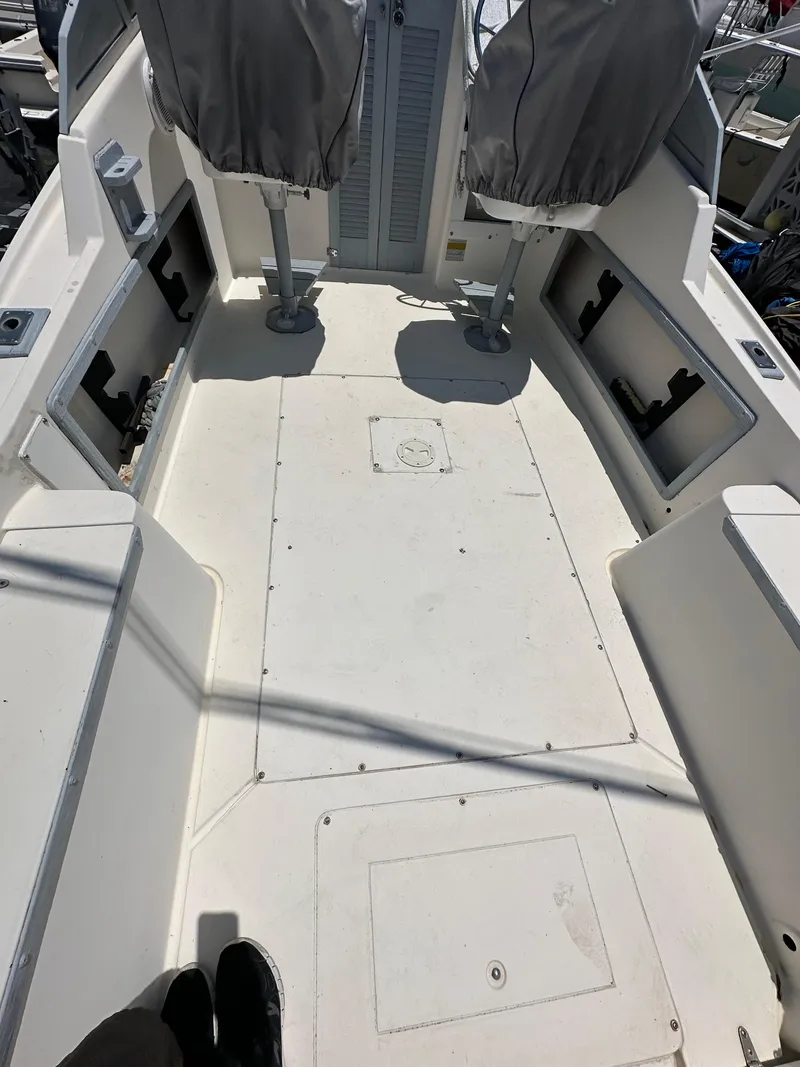 Slide: The Image of 1987 Mako 228 boat interior with covered seats and storage compartments. - 27