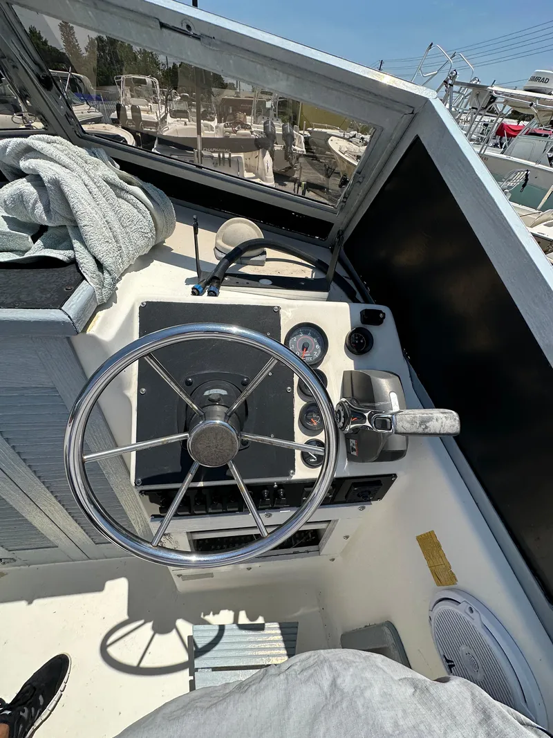 Slide: The Image of 1987 Mako 228 boat cockpit with steering wheel and gauges. - 28