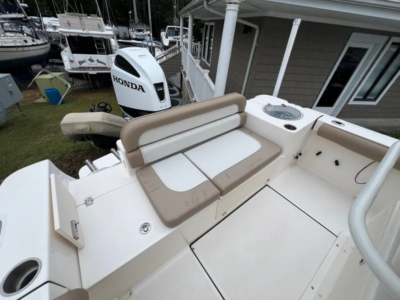 Slide: The Image of 2023 Sea Born LX24 Center Console boat with Honda outboard motor, docked near other vessels. - 18