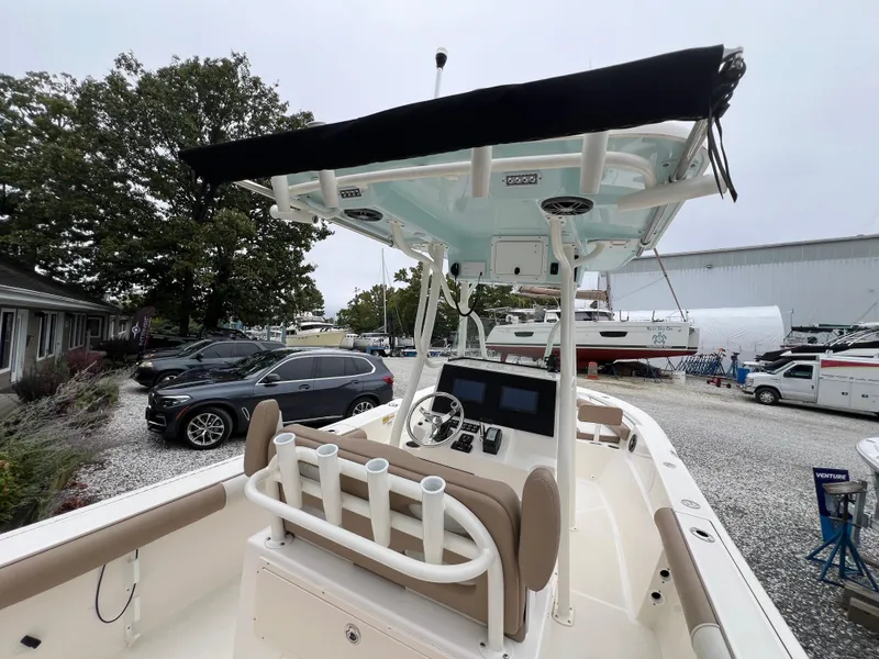 Slide: The Image of 2023 Sea Born LX24 Center Console boat with T-top in a marina setting. - 19