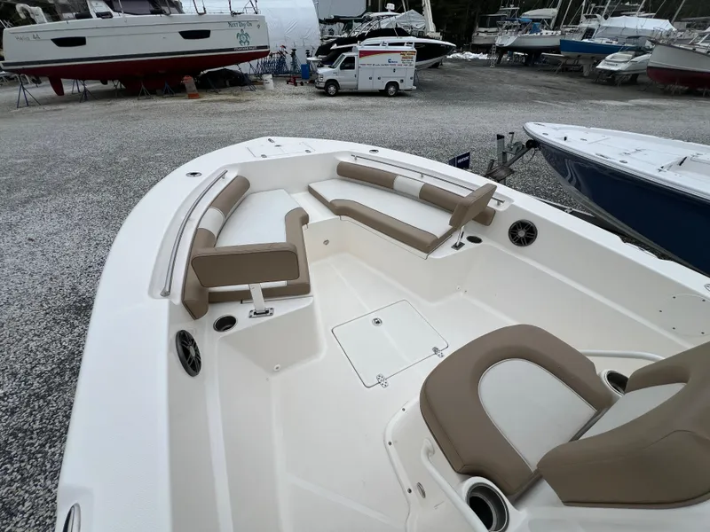 Slide: The Image of 2023 Sea Born LX24 Center Console boat with spacious seating in a marina setting. - 4