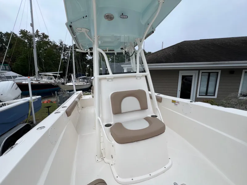 Slide: The Image of 2023 Sea Born LX24 Center Console boat with seating, docked near a house. - 6