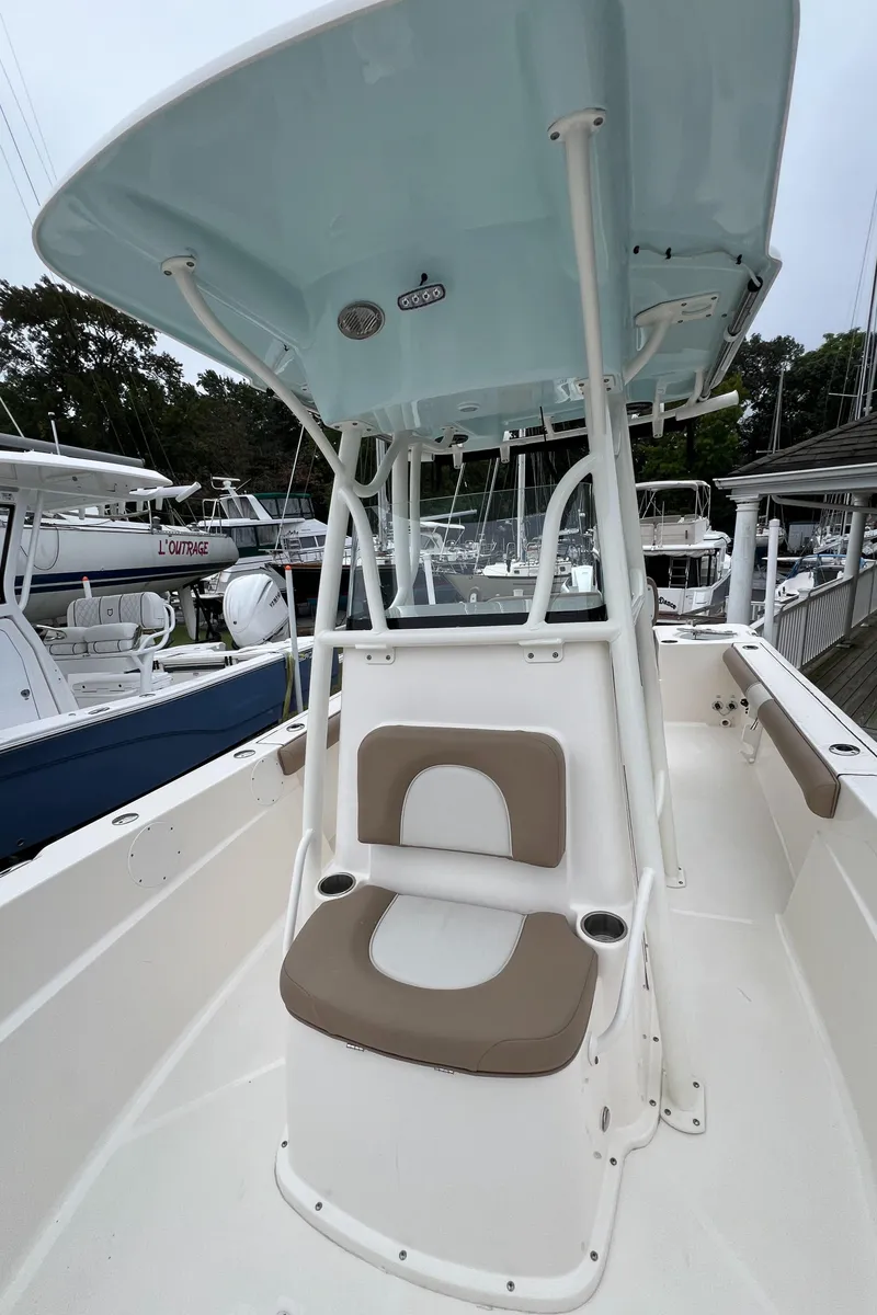 Slide: The Image of 2023 Sea Born LX24 Center Console boat with seating and T-top in a marina. - 8