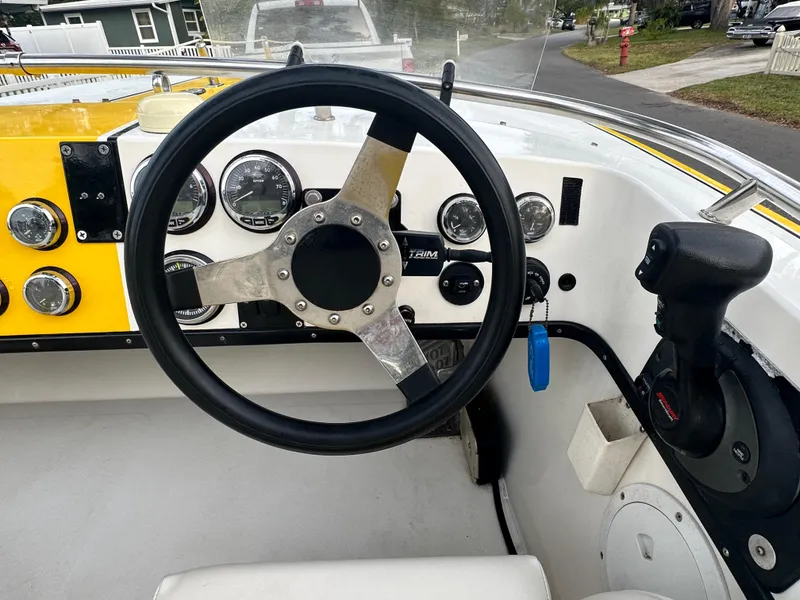 Slide: The Image of Steering wheel and dashboard of 1990 Superboat 21 with gauges and controls. - 1