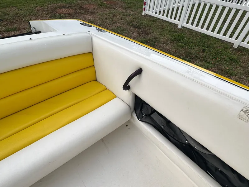 Slide: The Image of 1990 Superboat 21 interior with yellow and white seating, near white fence. - 14
