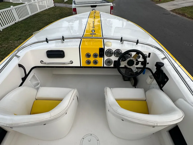Slide: The Image of 1990 Superboat 21 interior with yellow accents, dual seats, and steering wheel. - 19