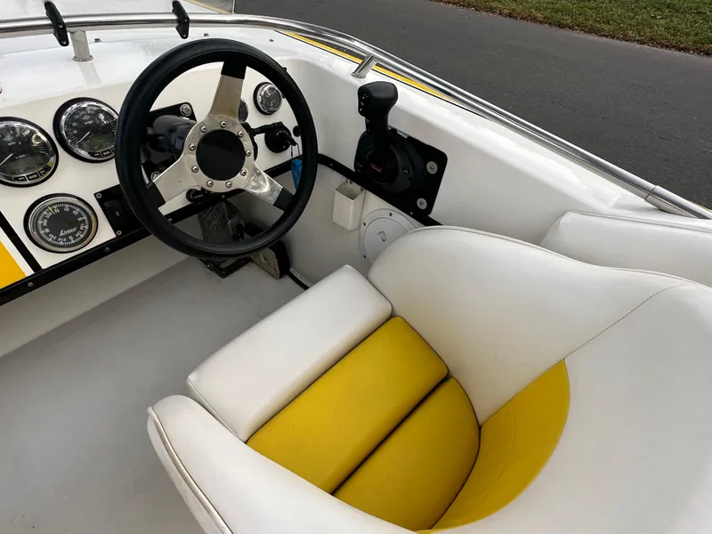 Slide: The Image of 1990 Superboat 21 cockpit with white and yellow seating, steering wheel, and gauges. - 21