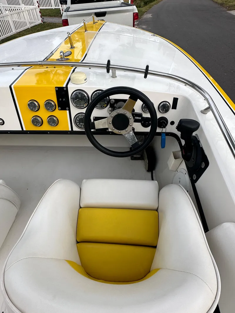 Slide: The Image of 1990 Superboat 21 cockpit with yellow and white seating, steering wheel, and dashboard controls. - 24