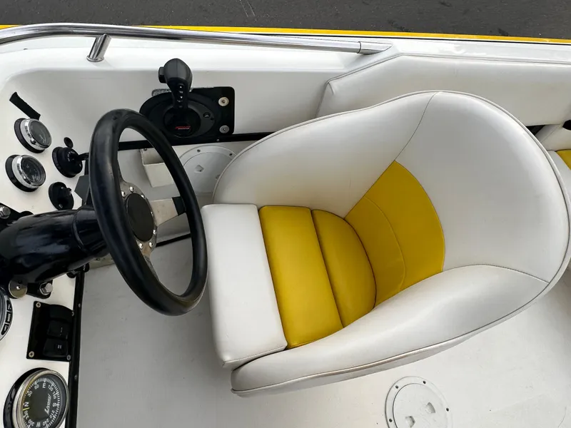 Slide: The Image of 1990 Superboat 21 cockpit with yellow and white seat, steering wheel, and control panel. - 27