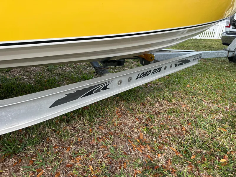 Slide: The Image of Yellow 1990 Superboat 21 on Load Rite trailer, parked on grass. - 35