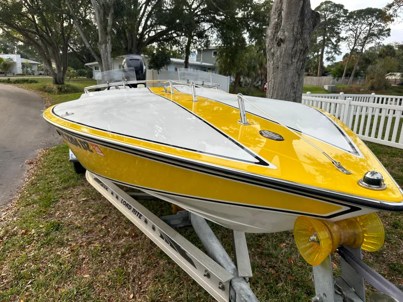 Slide: The Image of 1990 Superboat 21 on trailer, yellow and white design, parked outdoors. - 36