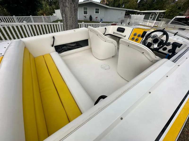 Slide: The Image of Interior of a 1990 Superboat 21 with yellow and white seating, steering wheel, and dashboard. - 40