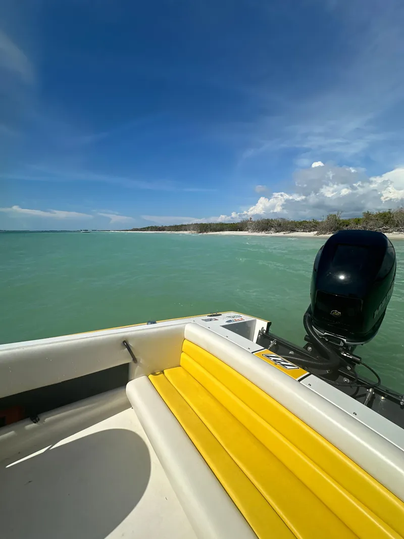 Slide: The Image of 1990 Superboat 21 on turquoise water, featuring yellow seating and outboard motor. - 45