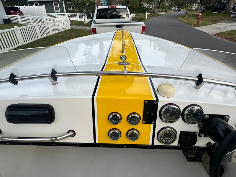 Slide: The Image of 1990 Superboat 21 dashboard with yellow stripe, gauges, and steering wheel. - 7