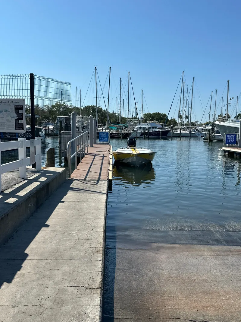 Slide: The Image of Yellow 1990 Superboat 21 docked at a marina with sailboats in the background. - 9