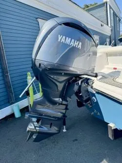 Slide: The Image of 2025 Tidewater 210CC Adventure with Yamaha outboard motor, docked near blue building. - 8