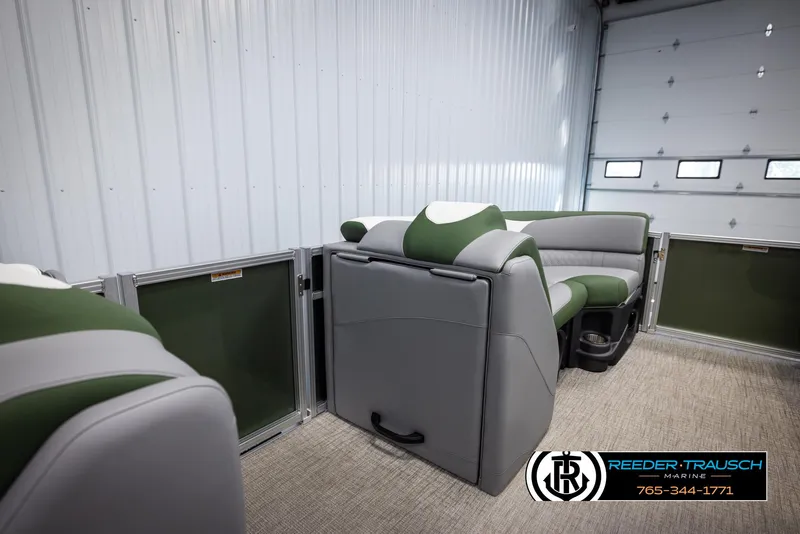 Slide: The Image of 2025 Avalon LSZ CRB boat interior with green and gray seating in a garage. - 20