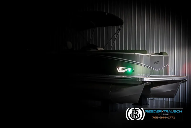 Slide: The Image of 2025 Avalon LSZ CRB pontoon boat in dimly lit showroom, Reeder-Trausch Marine logo visible. - 4