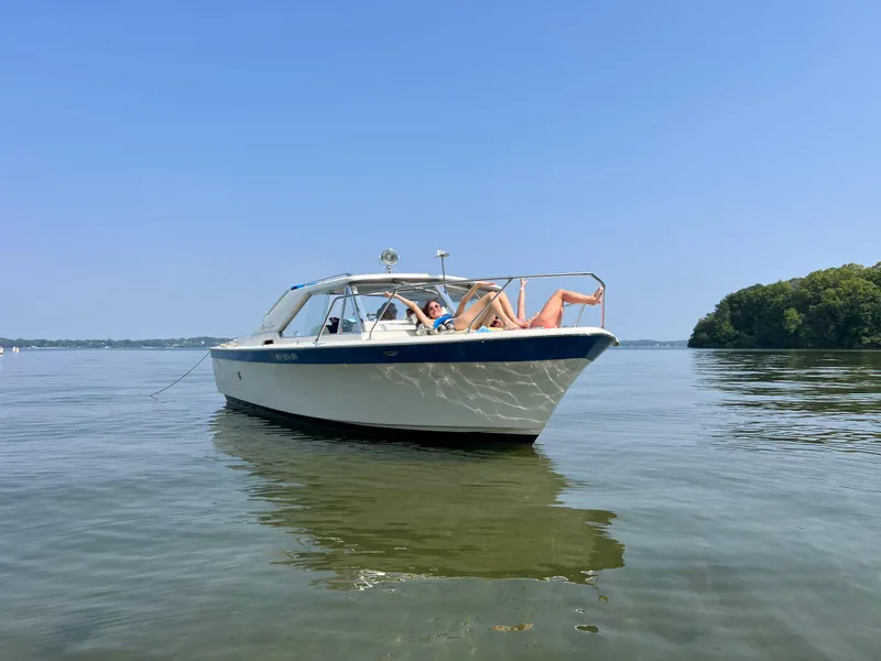 Slide: The Image of 1968 Chris-Craft COMMANDER 27 boat on calm water with people relaxing onboard. - 1