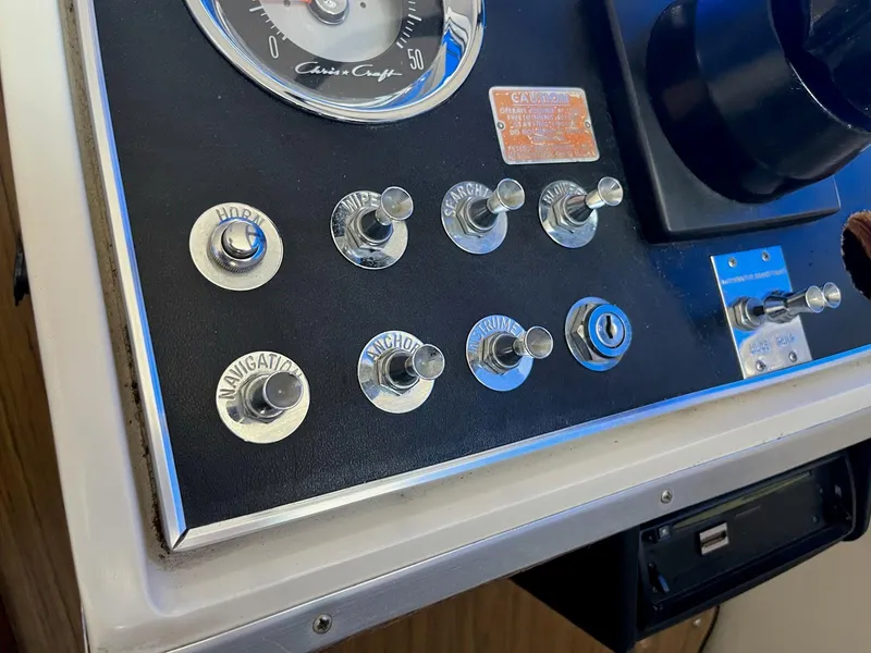 Slide: The Image of Control panel of a 1968 Chris-Craft COMMANDER 27 boat with labeled switches. - 12