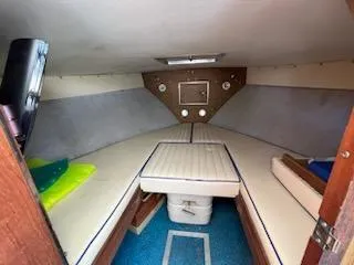 Slide: The Image of 1968 Chris-Craft COMMANDER 27 cabin interior with cushioned seating and wooden accents. - 23