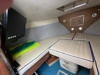 Slide: The Image of Interior cabin of a 1968 Chris-Craft COMMANDER 27 with cushioned seating and a mounted TV. - 24