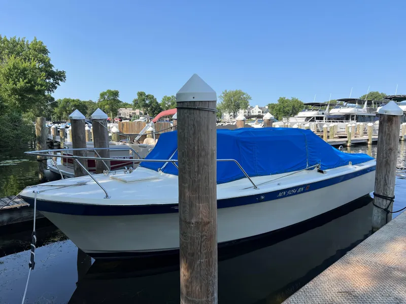 Slide: The Image of 1968 Chris-Craft COMMANDER 27 boat docked with blue cover, surrounded by marina. - 5