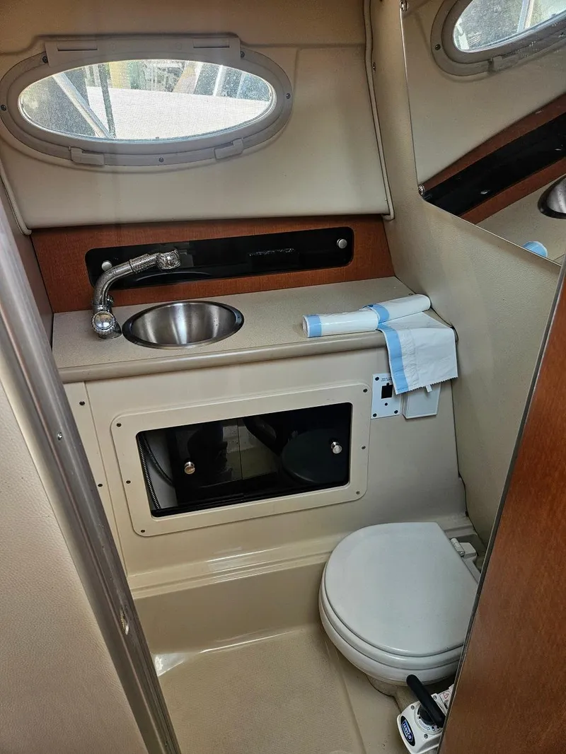 Slide: The Image of 2005 Robalo R265 Walkaround boat bathroom with sink, toilet, and storage. - 11
