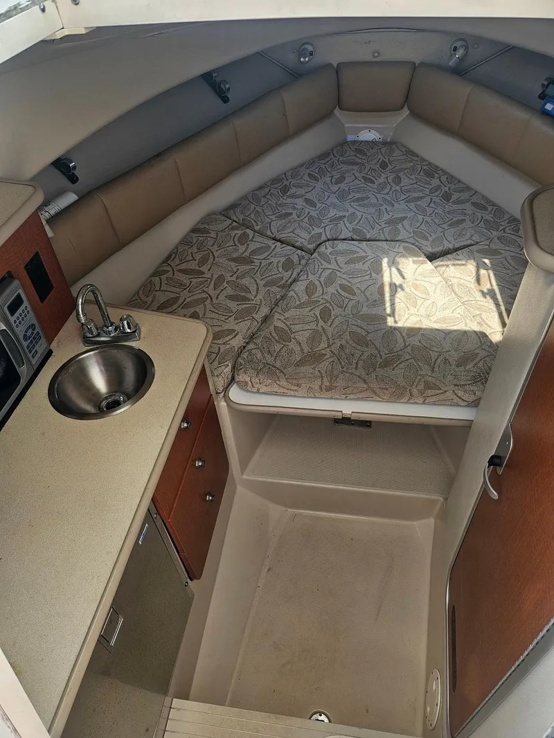 Slide: The Image of 2005 Robalo R265 Walkaround cabin interior with kitchenette and seating area. - 9