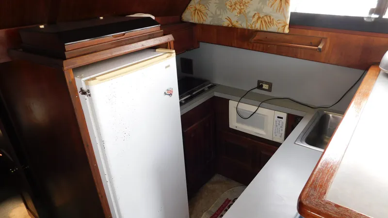 Slide: The Image of Compact kitchen area in a 1986 Viking 35 Sportfish boat with fridge and microwave. - 10