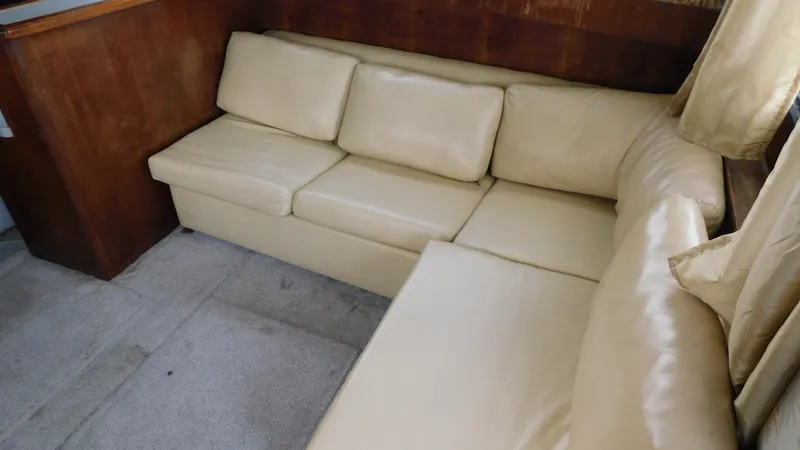 Slide: The Image of 1986 Viking 35 Sportfish interior with beige leather sofa and wooden paneling. - 13