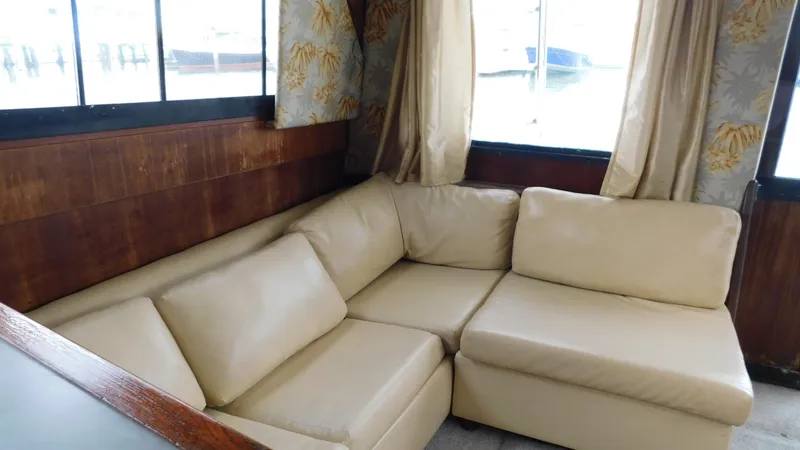 Slide: The Image of Interior of 1986 Viking 35 Sportfish with beige leather sofa and wood paneling. - 14