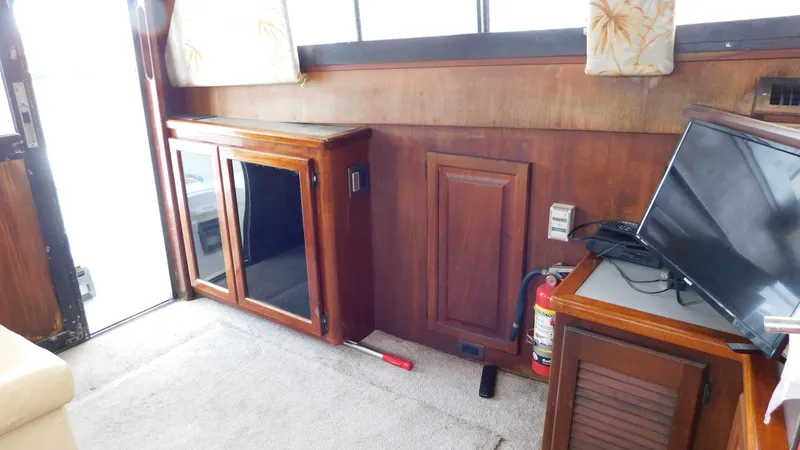 Slide: The Image of Interior of 1986 Viking 35 Sportfish with wood cabinets and a mounted TV. - 15