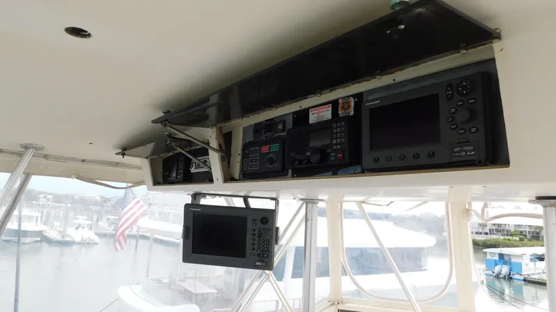 Slide: The Image of 1986 Viking 35 Sportfish helm with navigation equipment and marina view. - 22