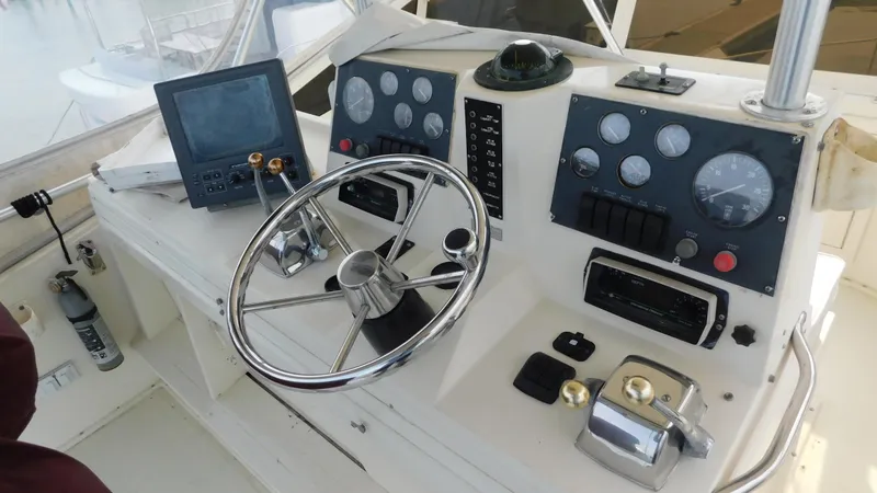 Slide: The Image of 1986 Viking 35 Sportfish helm with steering wheel, gauges, and navigation equipment. - 23