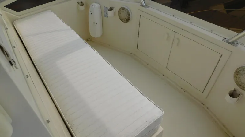 Slide: The Image of 1986 Viking 35 Sportfish boat interior with cushioned seating and storage cabinets. - 26