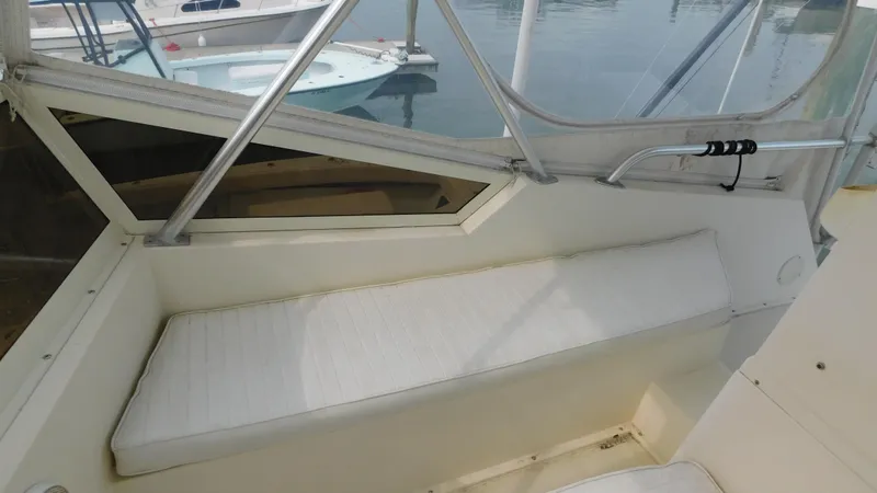 Slide: The Image of 1986 Viking 35 Sportfish boat interior with cushioned seating and window view. - 29