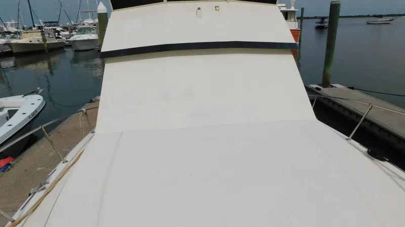 Slide: The Image of 1986 Viking 35 Sportfish boat docked at marina, view of deck and surrounding boats. - 34