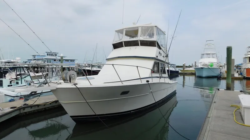 Slide: The Image of 1986 Viking 35 Sportfish boat docked in a marina, surrounded by other vessels. - 37