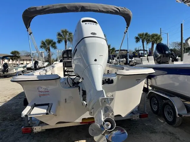 Slide: The Image of 2025 Carolina Skiff 21 LS boat with outboard motor and canopy, parked on trailer. - 3