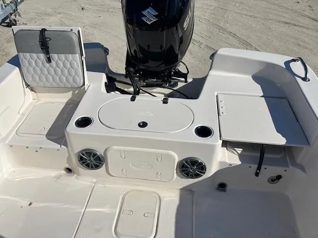 Slide: The Image of 2025 Carolina Skiff 23 LS boat interior with seating, storage, and Suzuki outboard motor. - 3