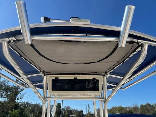 Slide: The Image of 2025 Carolina Skiff 23 LS boat canopy and rod holders under clear blue sky. - 5