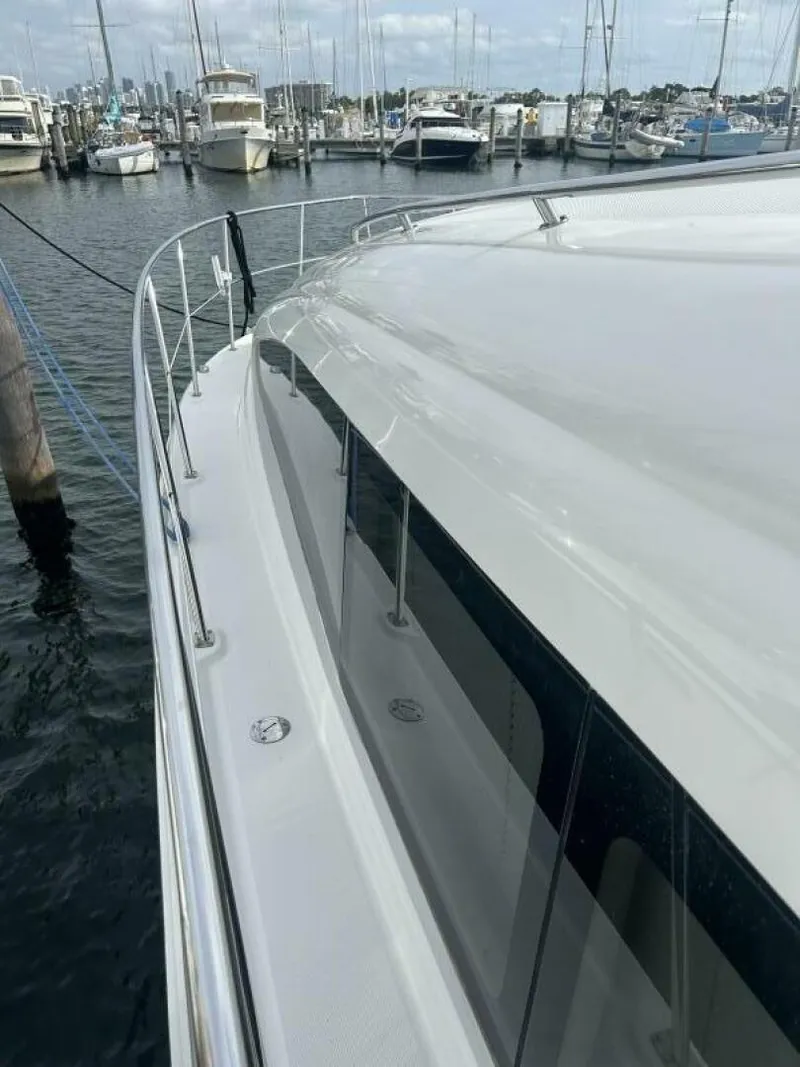 Slide: The Image of 2004 Sea Ray 390 Motor Yacht docked in marina, showcasing sleek design and railing. - 2