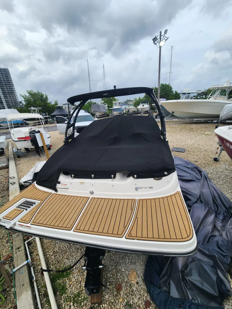 Slide: The Image of 2020 Sea Ray SPX 190 boat with black cover, parked on gravel lot. - 18
