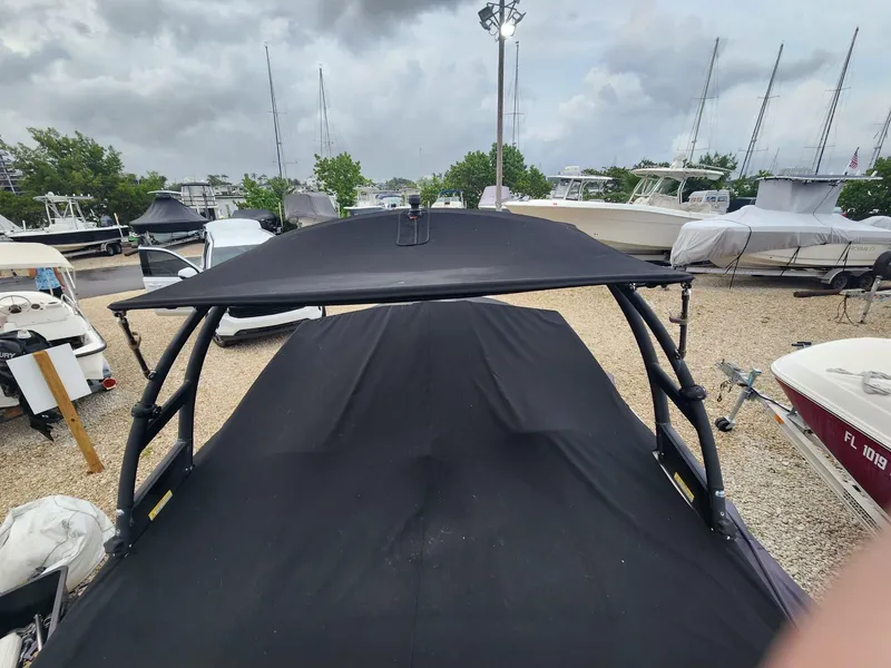 Slide: The Image of 2020 Sea Ray SPX 190 boat with black cover in a marina setting. - 20