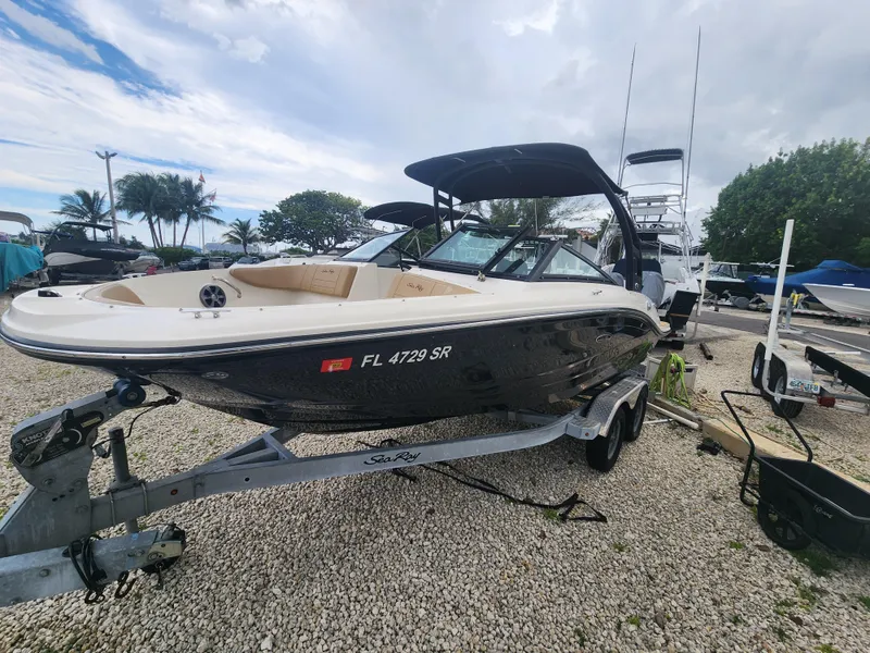 Slide: The Image of 2020 Sea Ray SPX 190 boat on trailer, parked outdoors with palm trees in background. - 3