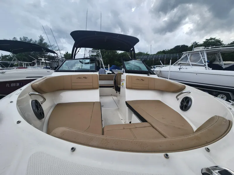 Slide: The Image of 2020 Sea Ray SPX 190 boat interior with tan seating and overcast sky. - 7